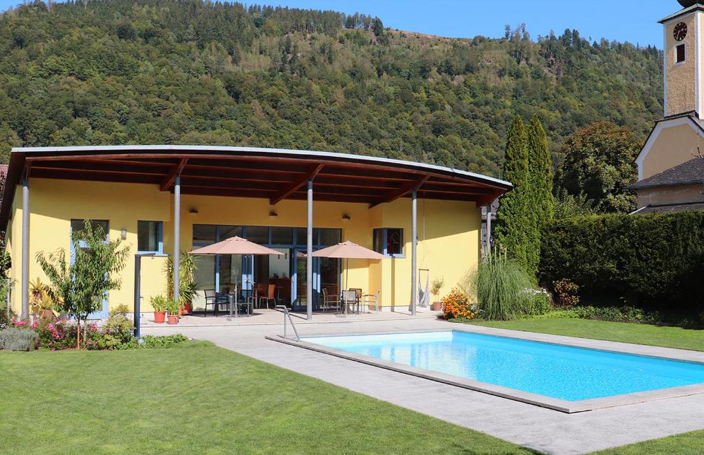 une maison avec une piscine en face d'un bâtiment dans l'établissement Gasthof-Pension Schütz, à Wesenufer
