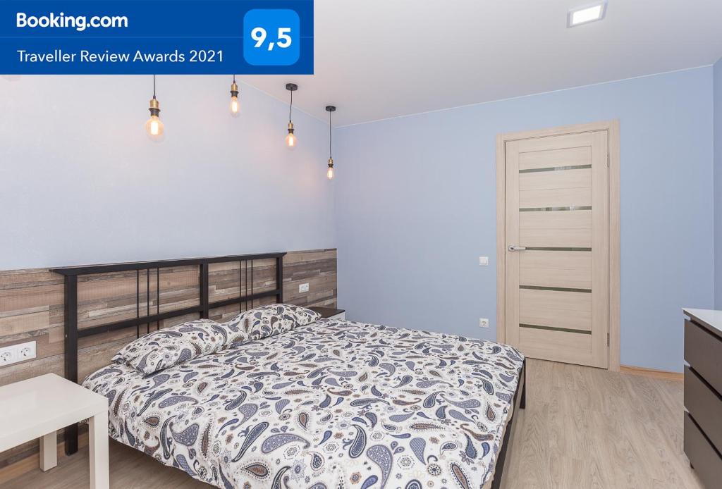 a bedroom with a bed and a white wall at Metro Krasny Prospekt Apartment in Novosibirsk