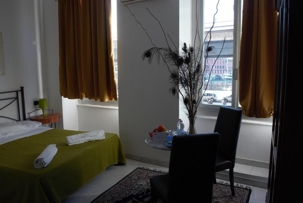 1 dormitorio con cama, mesa y ventana en Red and Blues Music Hotel Genova, en Génova