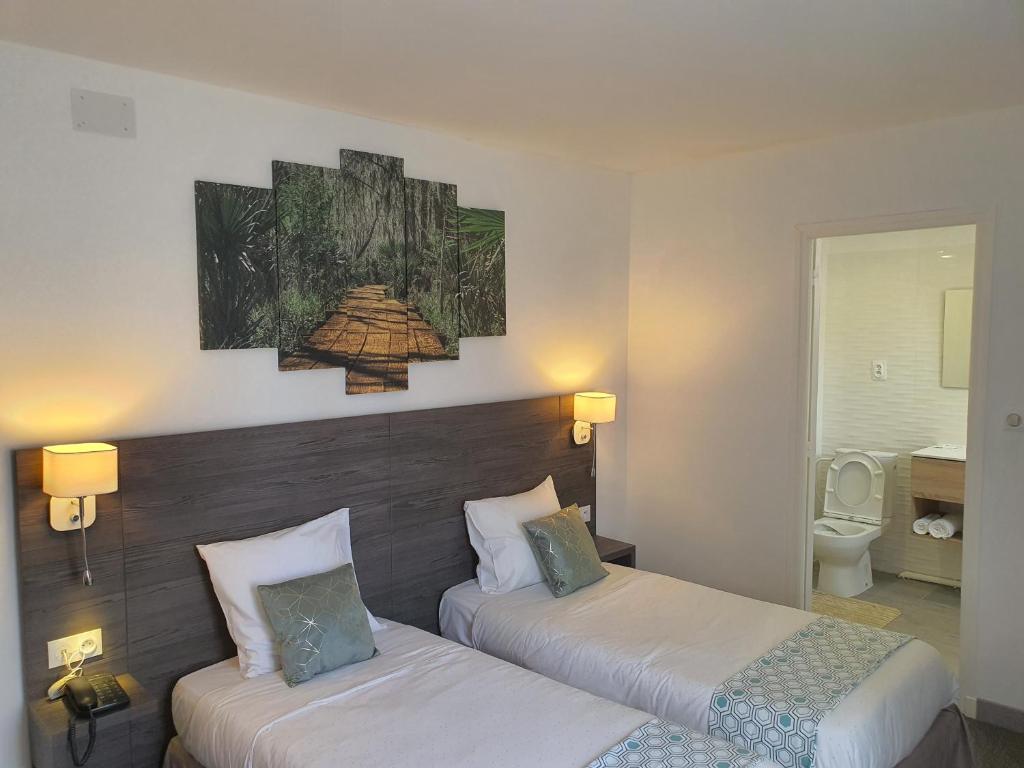 Postel nebo postele na pokoji v ubytování Hôtel L'Alsace-Gare sncf