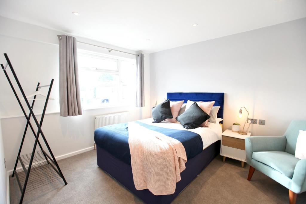 a bedroom with a blue bed and a blue chair at Stylish Cambridge City Pad in Chesterton
