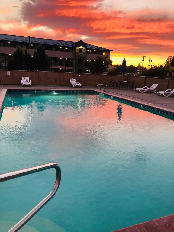 a large swimming pool with a sunset in the background at Sugarloaf Mountain Motel in Bend