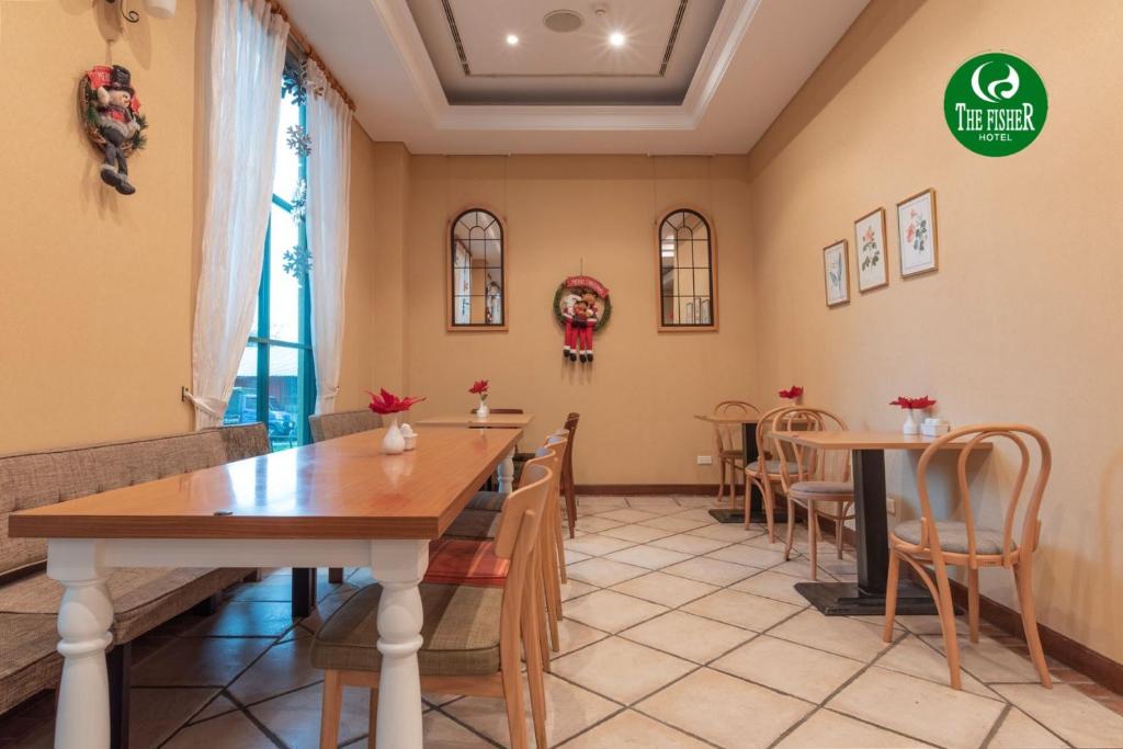 a restaurant with tables and chairs in a room at The Fisher Hotel in Tamsui