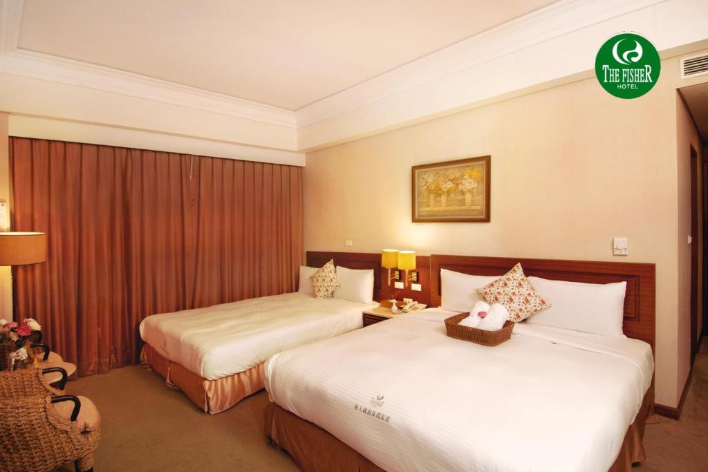 a hotel room with two beds in a room at The Fisher Hotel in Tamsui