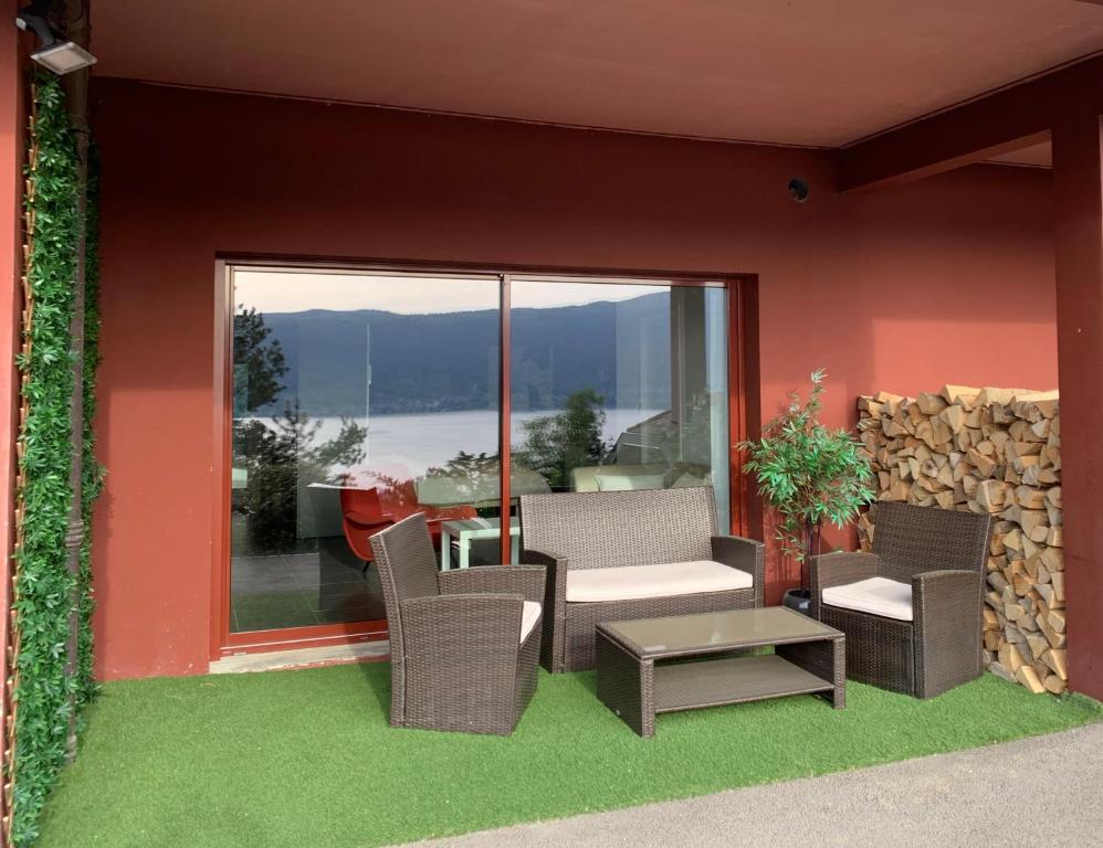 a patio with chairs and a table and a window at La Merle in Veyrier-du-Lac