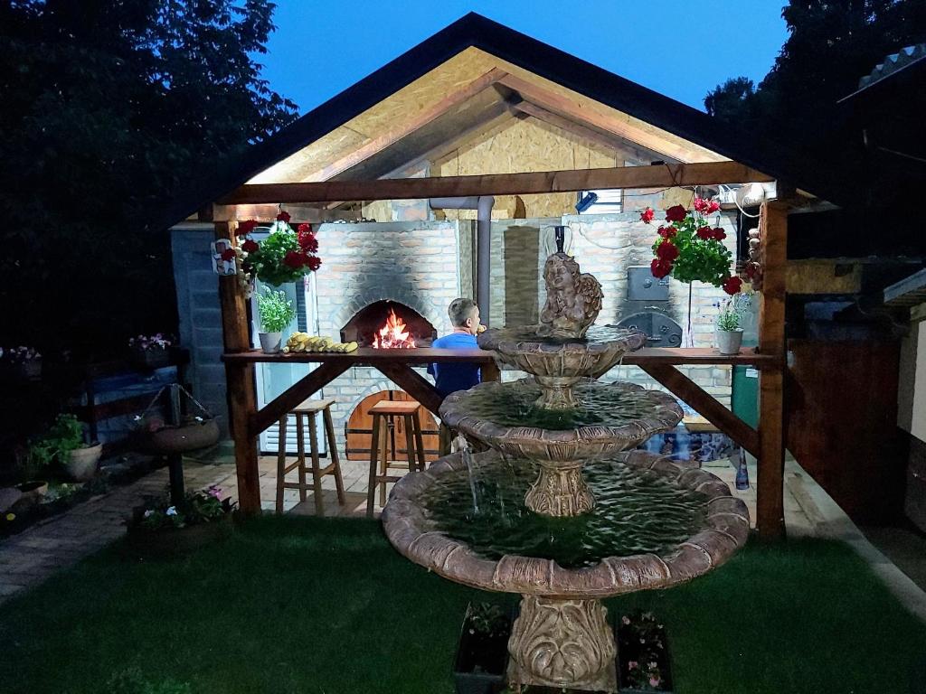 a backyard with a gazebo with a fountain and a fireplace at Gorica in Vrdnik