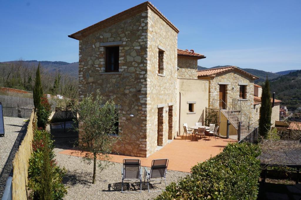 kamienny dom z krzesłami i patio w obiekcie Borgo di Gaiole - Casa BD - apartment with a view & travel guide w mieście Gaiole in Chianti