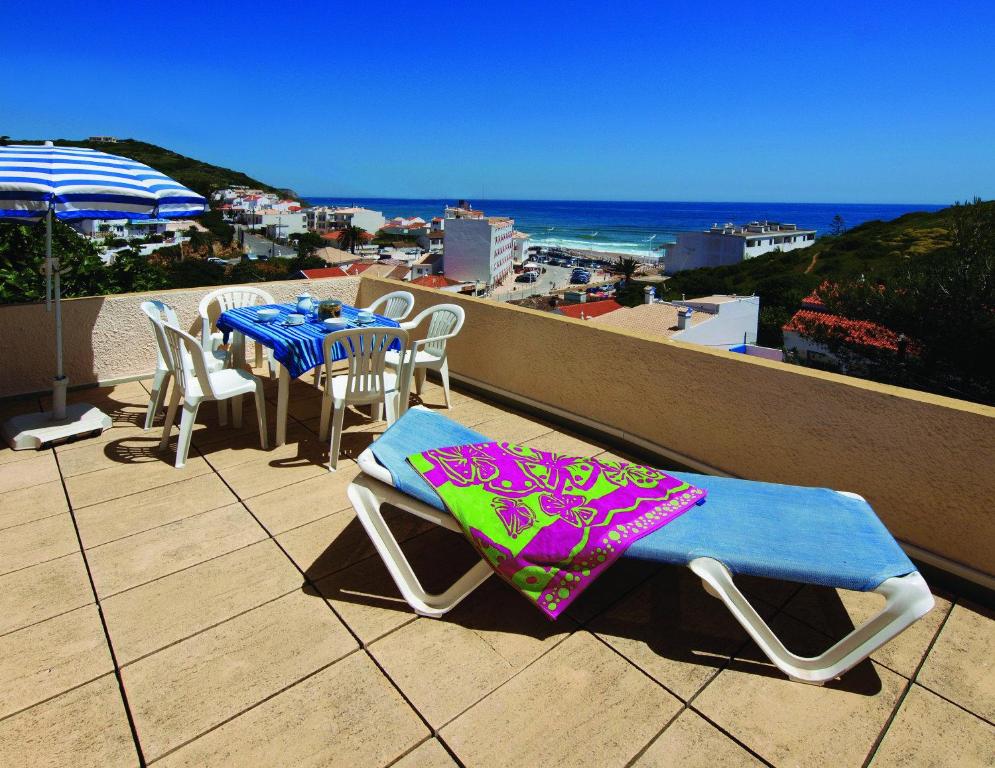 una mesa y sillas en un balcón con vistas al océano en Seaview Apartments, en Salema