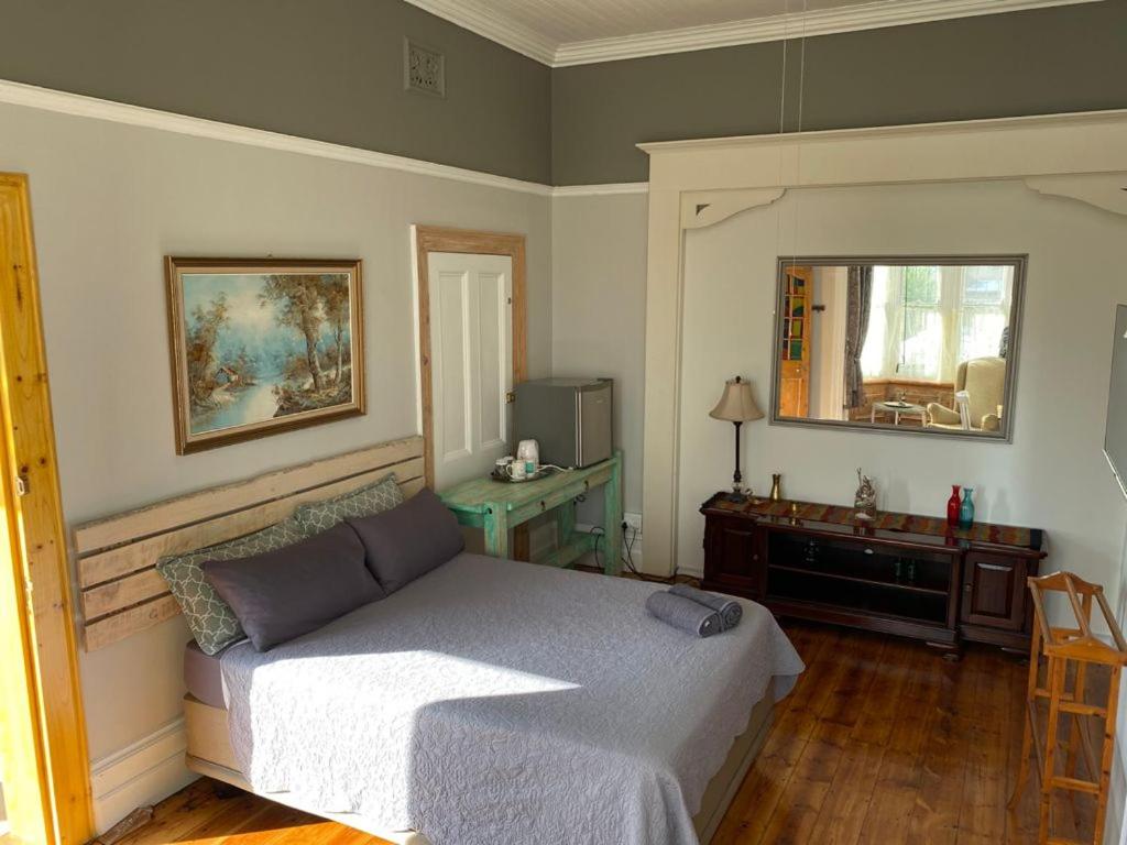 ポートエリザベスにあるHeath Villa - private roomのベッドルーム(ベッド1台、デスク、鏡付)