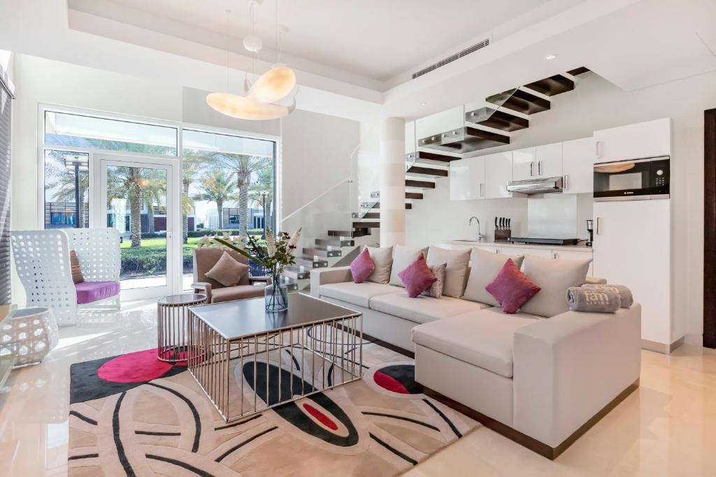 a living room filled with furniture and a large window at FAM Living - Sarai Villas in Dubai