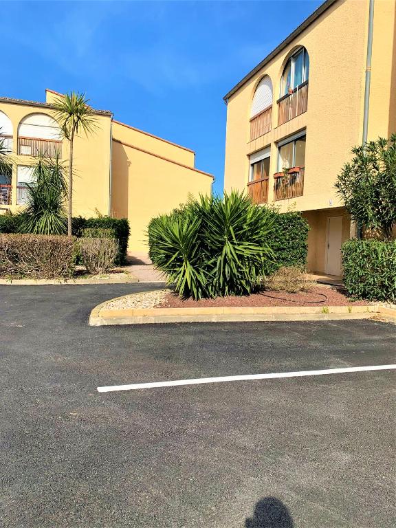 un parking devant un immeuble dans l'établissement Appartement cosy à deux pas du port, à Saint-Cyprien
