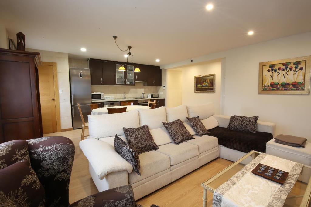 ein Wohnzimmer mit einem weißen Sofa und einer Küche in der Unterkunft Apartamento Oviedo San Melchor in Oviedo