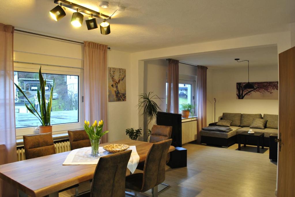 a dining room and living room with a table and a couch at Haus Waldesruh in Lennestadt
