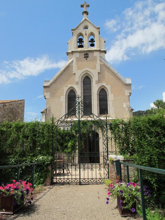 una iglesia con una puerta con una cruz en la parte superior en La chapelle de Melin, en Auxey-Duresses