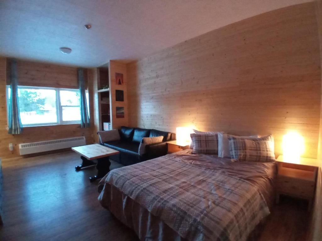 ein Schlafzimmer mit einem großen Bett und einem Sofa in der Unterkunft Schoolhouse Inn in Killaloe Station