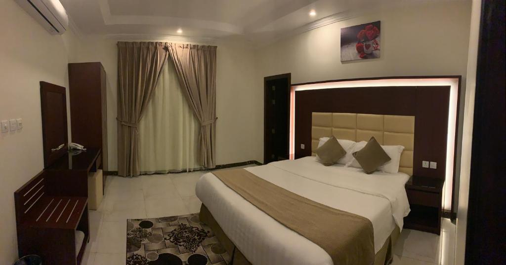 Un dormitorio con una cama grande y una ventana en دانة الشرق للشقق المخدومة en Al Khobar