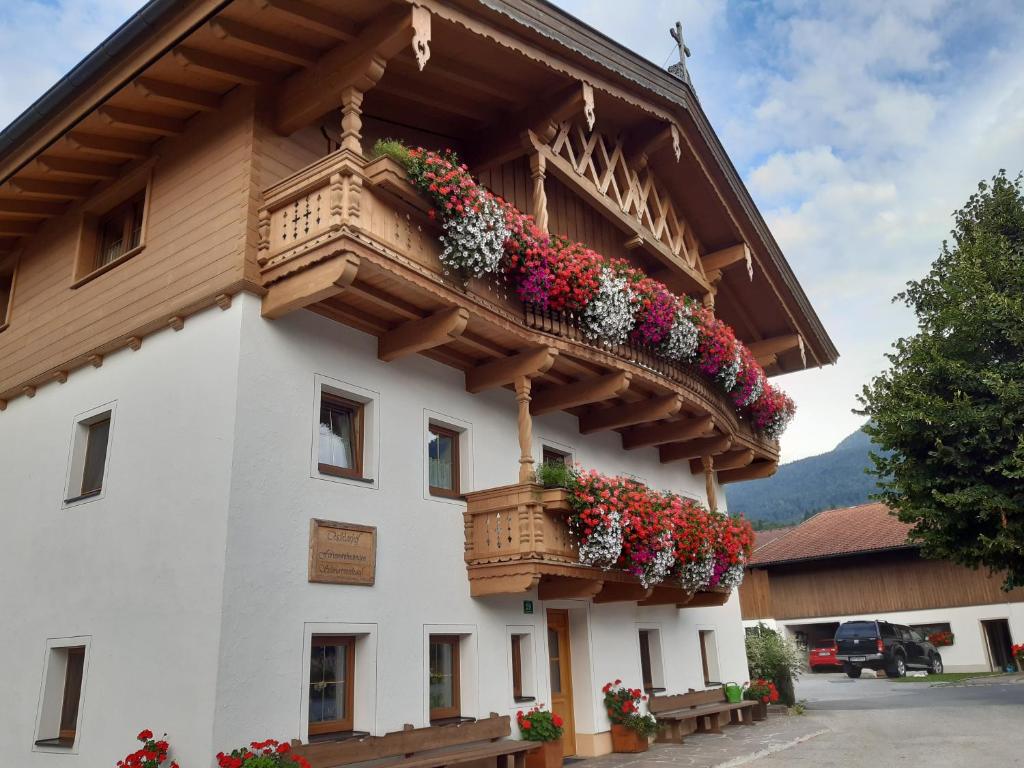 un bâtiment avec des boîtes de fleurs sur son côté dans l'établissement Ferienwohnungen Tischlerhof, à Ebbs