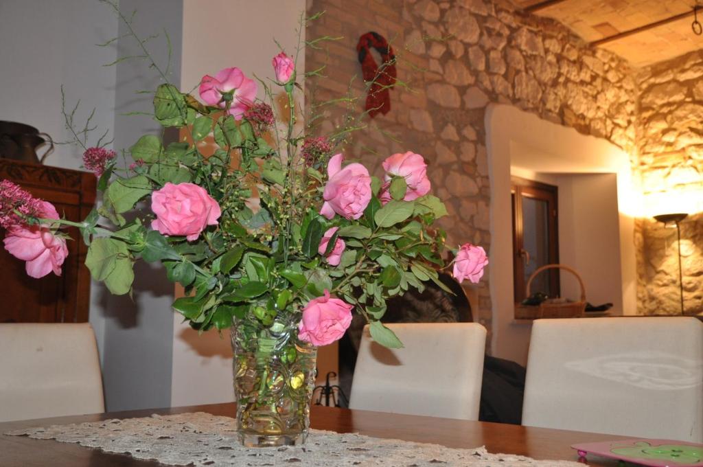 eine Vase voller rosa Rosen auf dem Tisch in der Unterkunft LA QUERCIA Appartamenti in Ortona