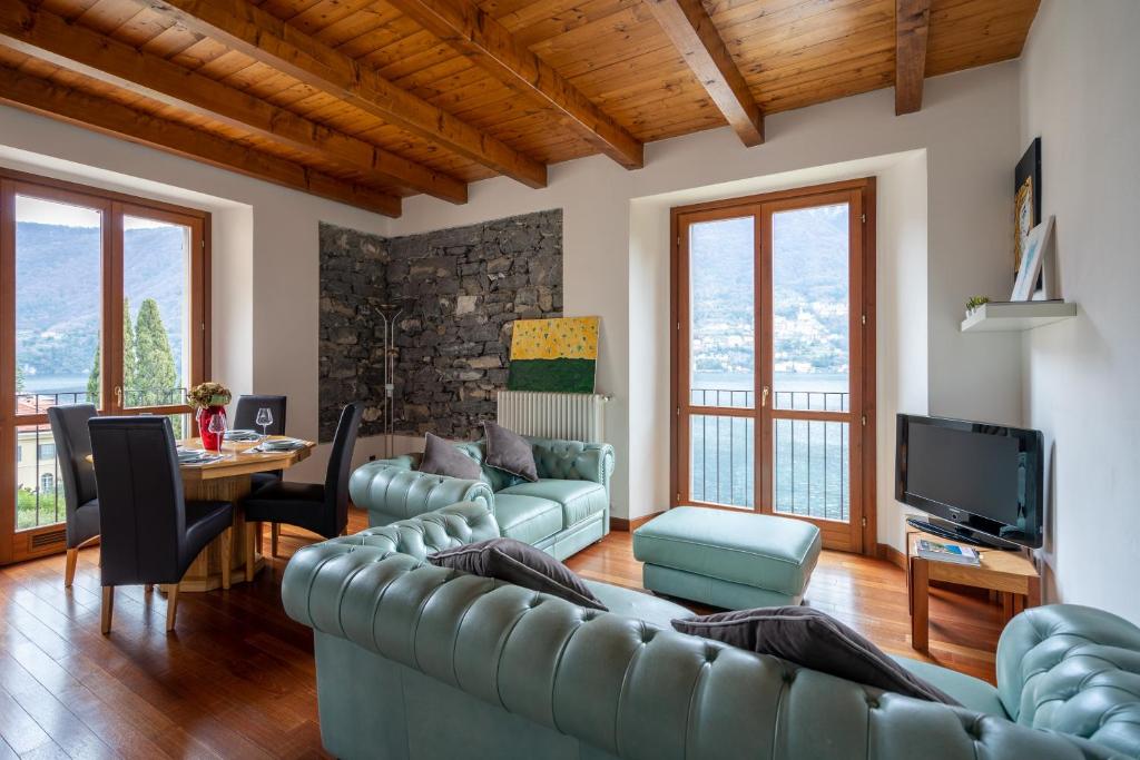sala de estar con sofá, mesa y TV en Silvia Apartment - Residence Regina en Laglio