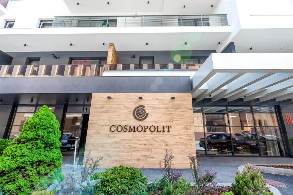 a cosmopolitan hotel with a sign on the front of it at Warm Amber Suites Brașov in Braşov