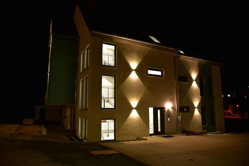 un edificio con luces de noche. en Apartment Aurachtal Münchaurach, en Falkendorf
