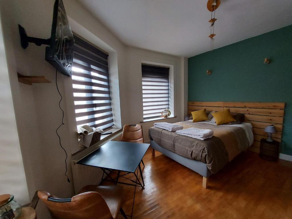 um quarto com uma cama e uma mesa em Le cocon em La-Roche-en-Ardenne