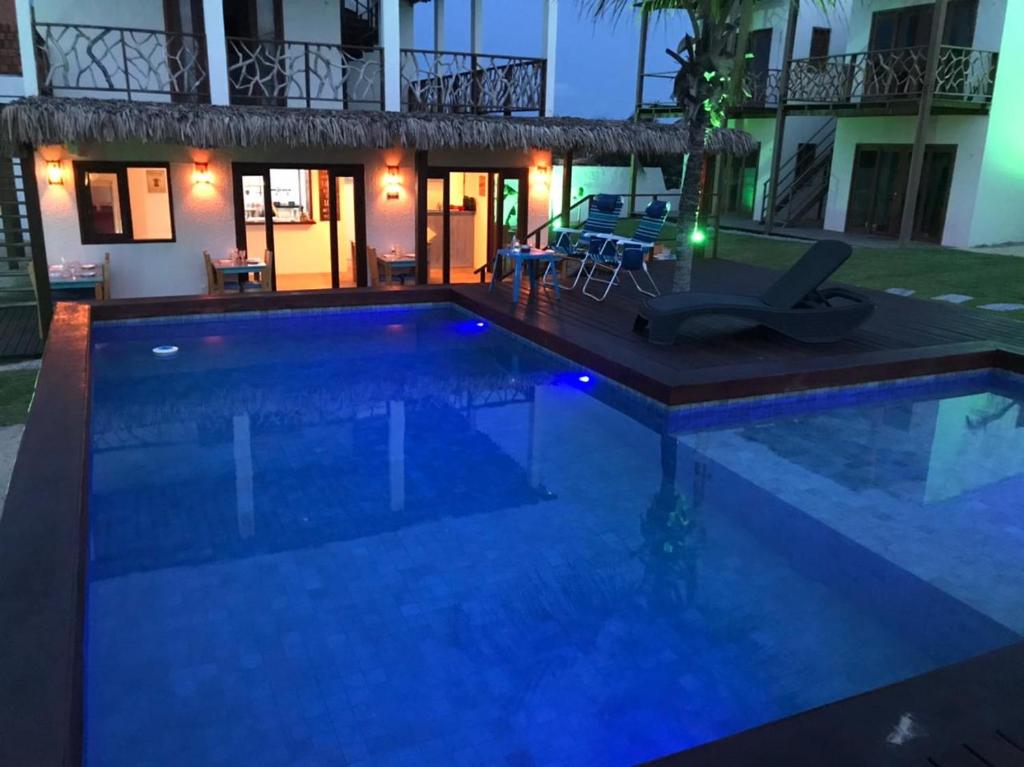 uma piscina em frente a uma casa à noite em UMAMI RESIDENCE em Icaraí