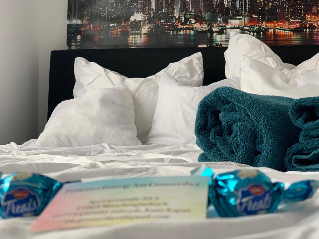 Una cama con sábanas blancas y toallas azules. en Geroweiher Doppelbettzimmer Mönchengladbach-Stadtmitte, en Mönchengladbach