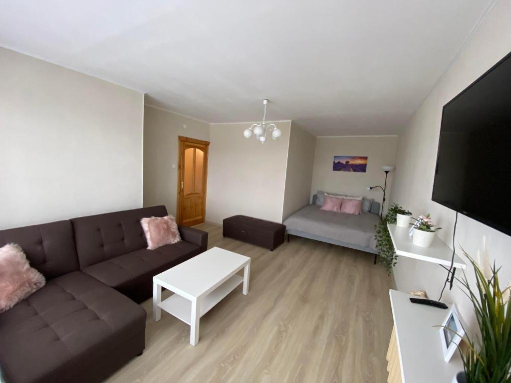 a living room with a couch and a bed at Apes ielas apartaments in Alūksne