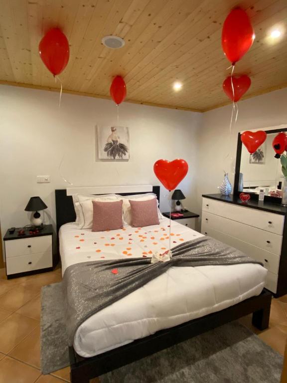 um quarto com coraes vermelhos pendurados no tecto em Alojamento Pelourinho em Melo