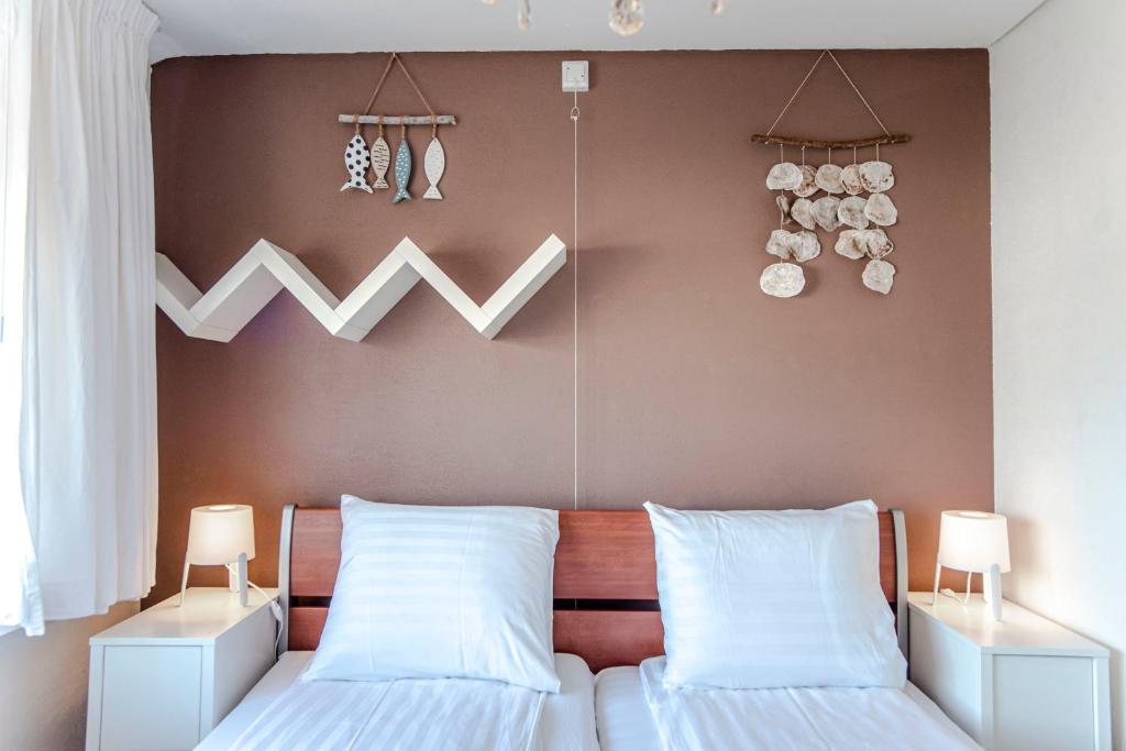 - une chambre avec 2 lits et des oreillers blancs dans l'établissement Sea Star Stay with Private Parking!, à Zandvoort