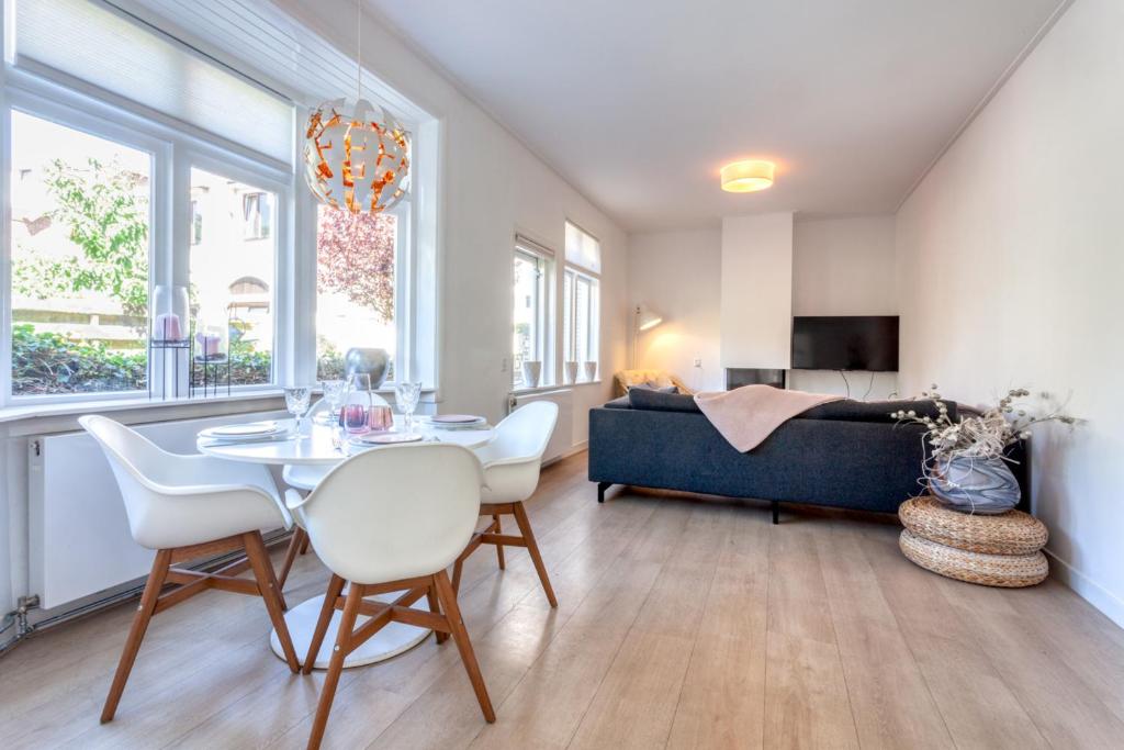 ein Wohnzimmer mit einem Tisch, Stühlen und einem Sofa in der Unterkunft Casa Vos Family Home in Zandvoort