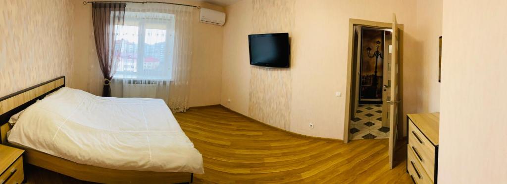 a bedroom with a bed and a tv on the wall at PortCity in Lutsk