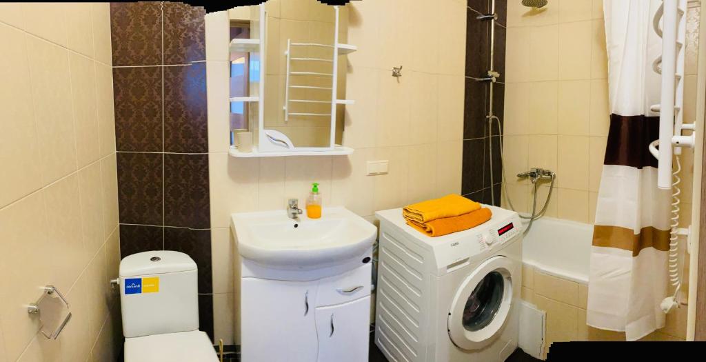 a bathroom with a sink and a washing machine at PortCity in Lutsk