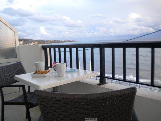 
a dining room table with a balcony overlooking the ocean at Katerina Studios & Apartments in Ierápetra
