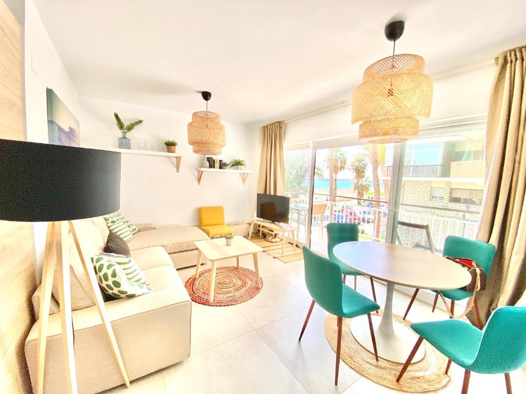 salon z kanapą, stołem i krzesłami w obiekcie Smart Malagueta Seaview w Maladze