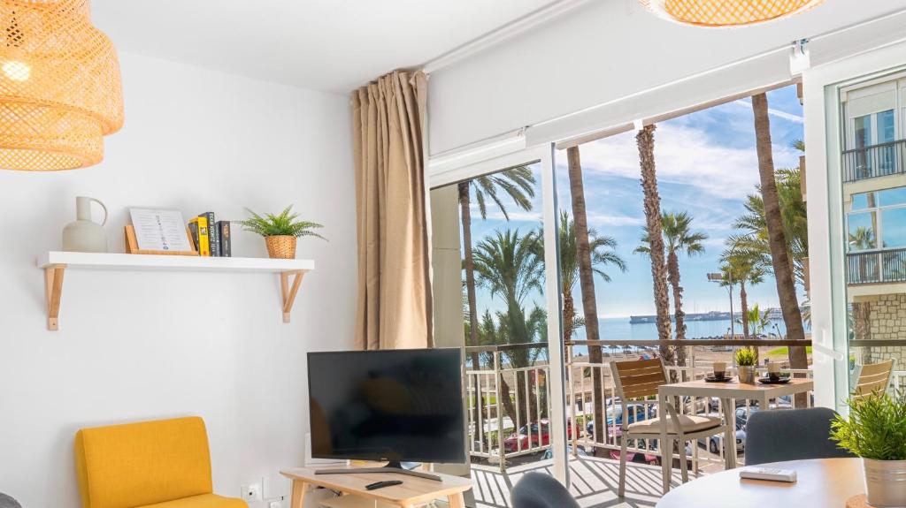salon z telewizorem i balkonem z palmami w obiekcie Smart Malagueta Seaview w Maladze