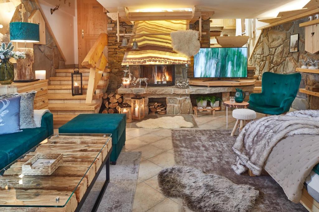 Cette chambre comprend un lit et une cheminée. dans l'établissement Witkówka WILD Luxury Apartments - Sauna & SPA, à Witów