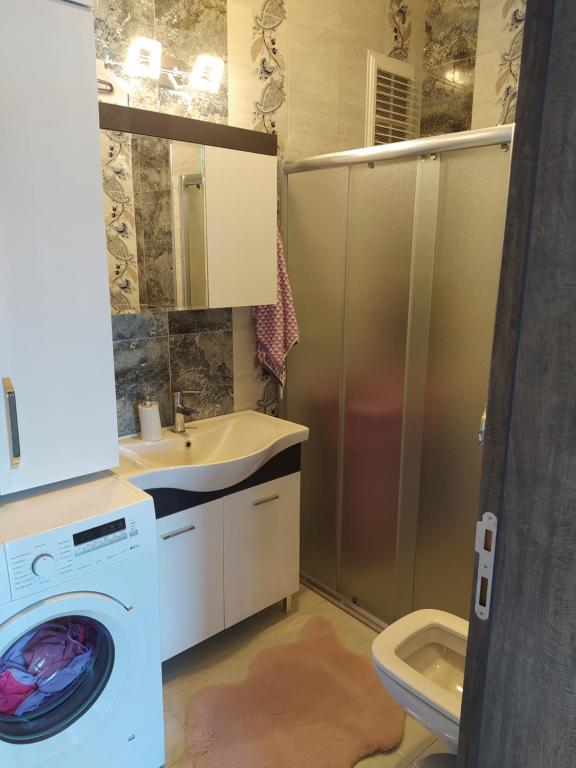 een badkamer met een wasmachine en een wastafel bij SULTAN KonaK in Altınoluk