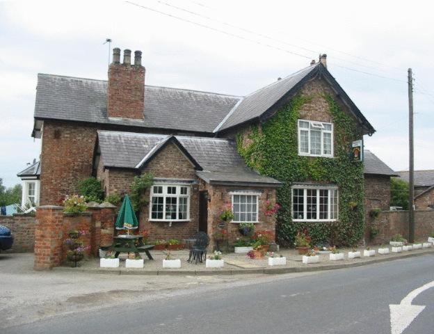 a brick house with ivy on the side of it at Thompsons Arms in Flaxton