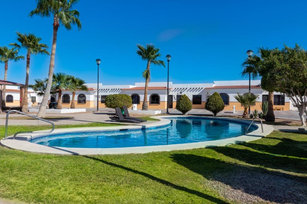 a swimming pool in a park with palm trees at Mexican Ambience Townhome with Pool #2 in Puerto Peñasco