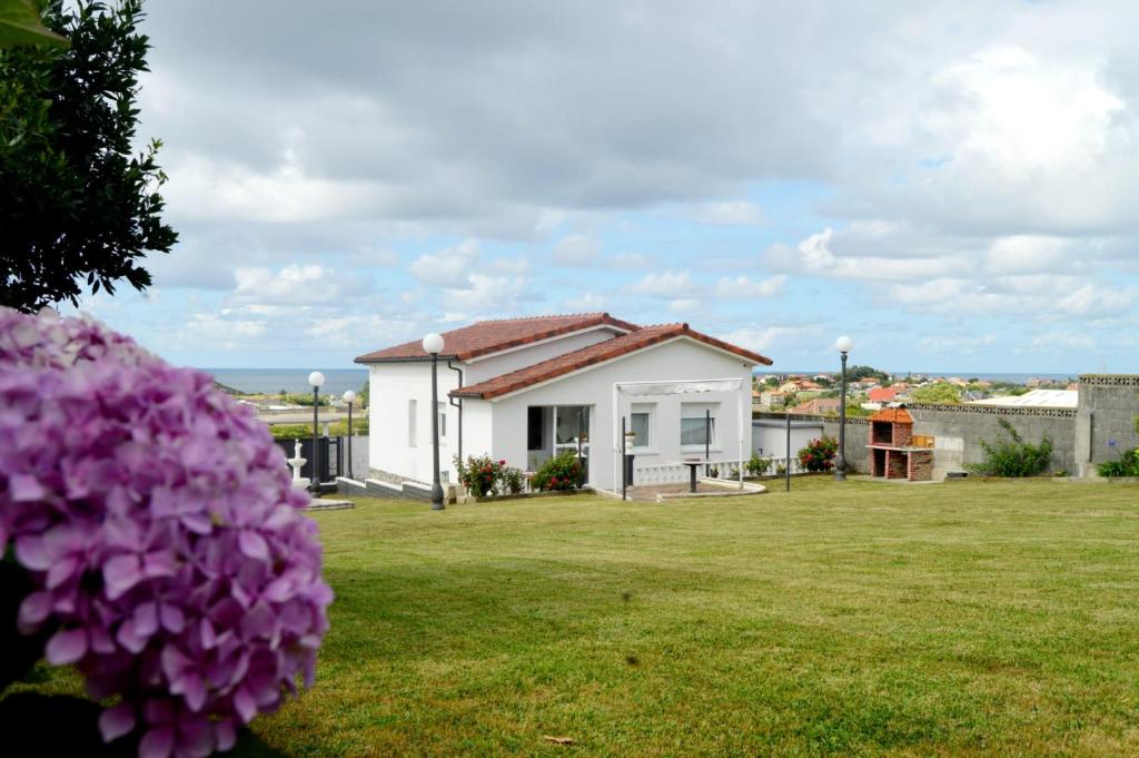 una casa blanca con un patio con flores púrpuras en Casa José, en Monte