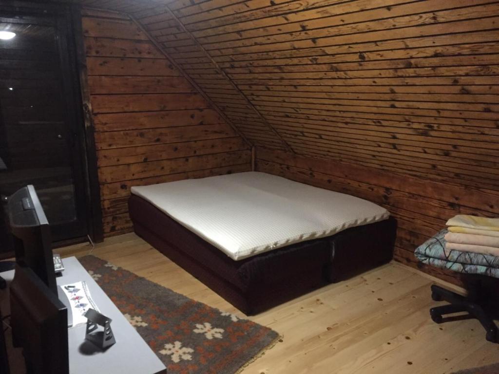 a mattress bed in a room with a brick wall at Vikendica Lenka in Sijarinska Banja