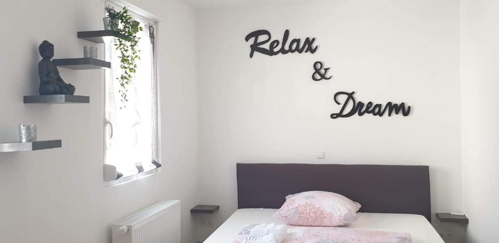 Un dormitorio con una cama y un letrero que lee relajarse y ahogarse en Comfortable new Apartment in #Koblenz# direkt am Rhein en Koblenz