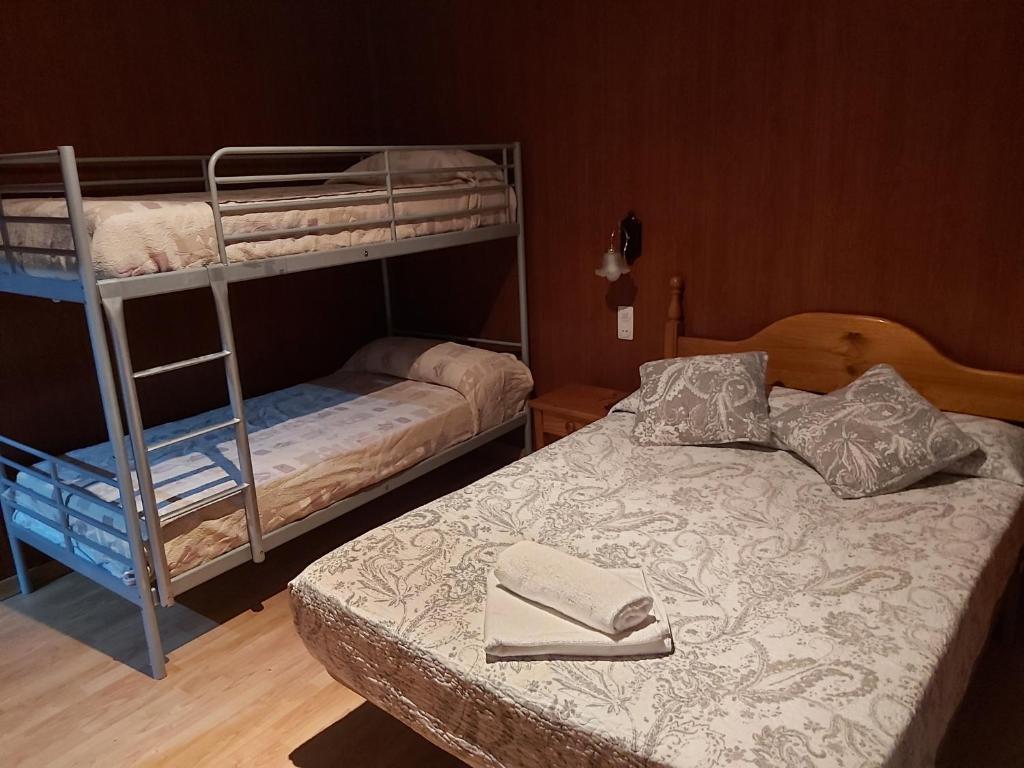 1 Schlafzimmer mit 2 Etagenbetten und 1 Bett in der Unterkunft Hostal Porta De Núria in Ribes de Freser