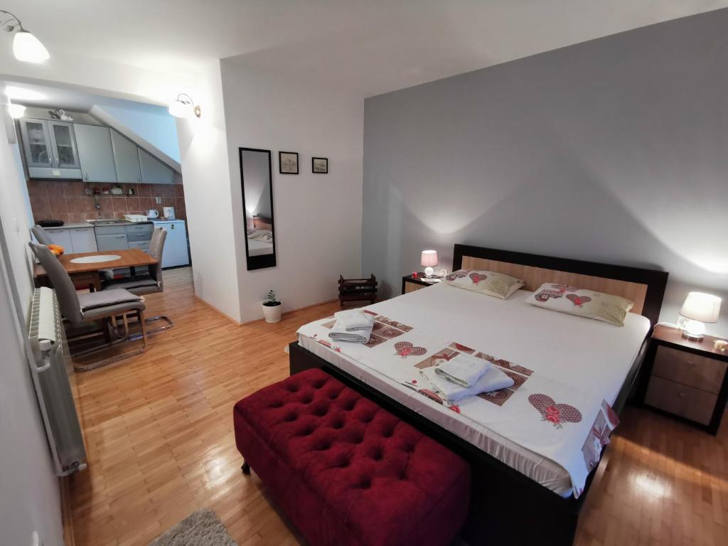 a bedroom with a large bed and a red bench at Apartment Vukasevic in Virpazar
