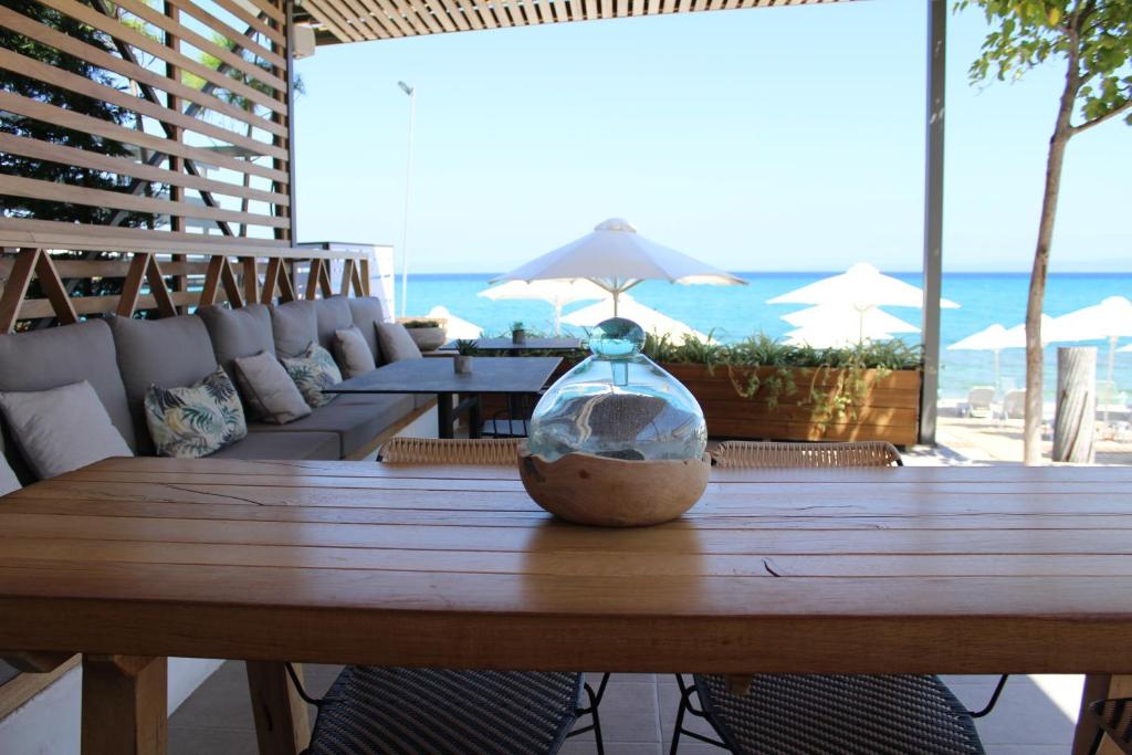 a vase sitting on a wooden table on the beach at Ostria Sea Side Hotel in Hanioti
