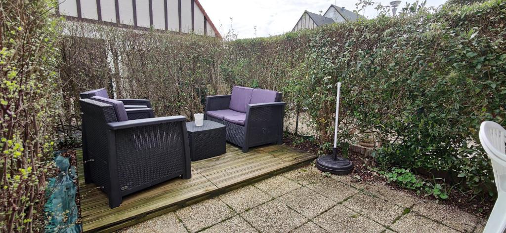 two chairs and a table on a wooden deck at La Kaz in Courseulles-sur-Mer