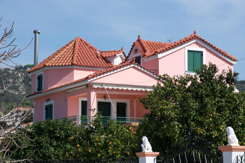 ein rosa Haus mit rotem Dach in der Unterkunft Alkmini Studio in Minia