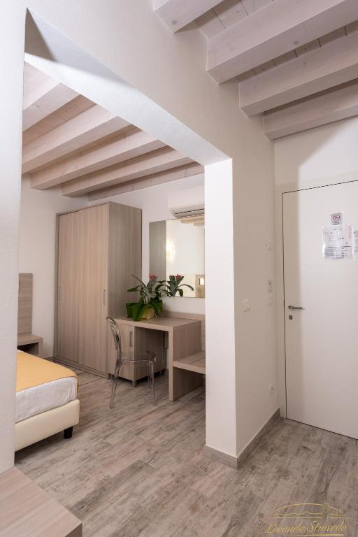a bedroom with a bed and a desk in a room at Locanda Stravedo in Pellestrina